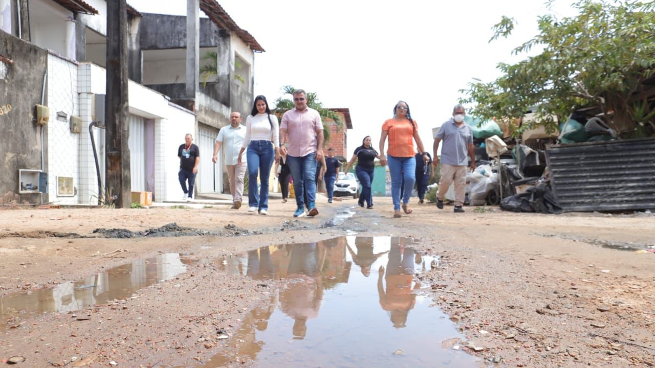 grupo de pessoas caminhando em uma rua sem calçamento